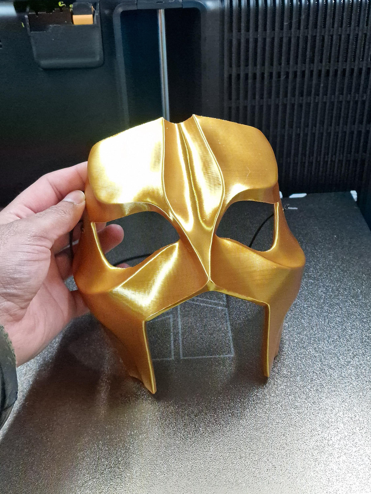 Gold mask held in hand