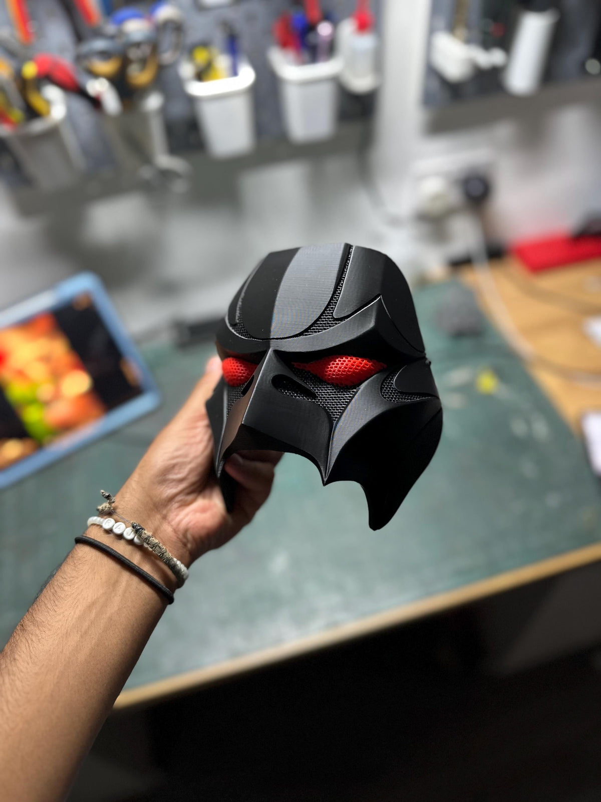 Matte black Weeknd 2026 tour mask with red mesh eyes